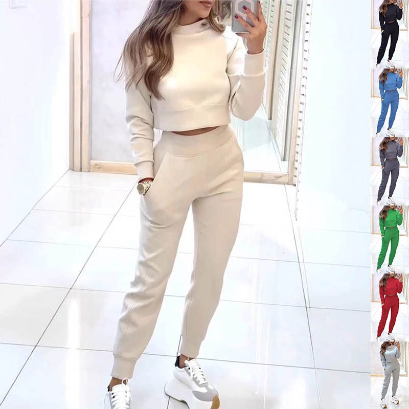 طقم رياضي نسائي أنيق بياقة مرتفعة، يتكون من بلوزة قصيرة بأكمام طويلة وتصميم "بلوفر"، مع بنطال ضيق مزود بجيوب، بلون سادة ليناسب إطلالتك اليومية المريحة.