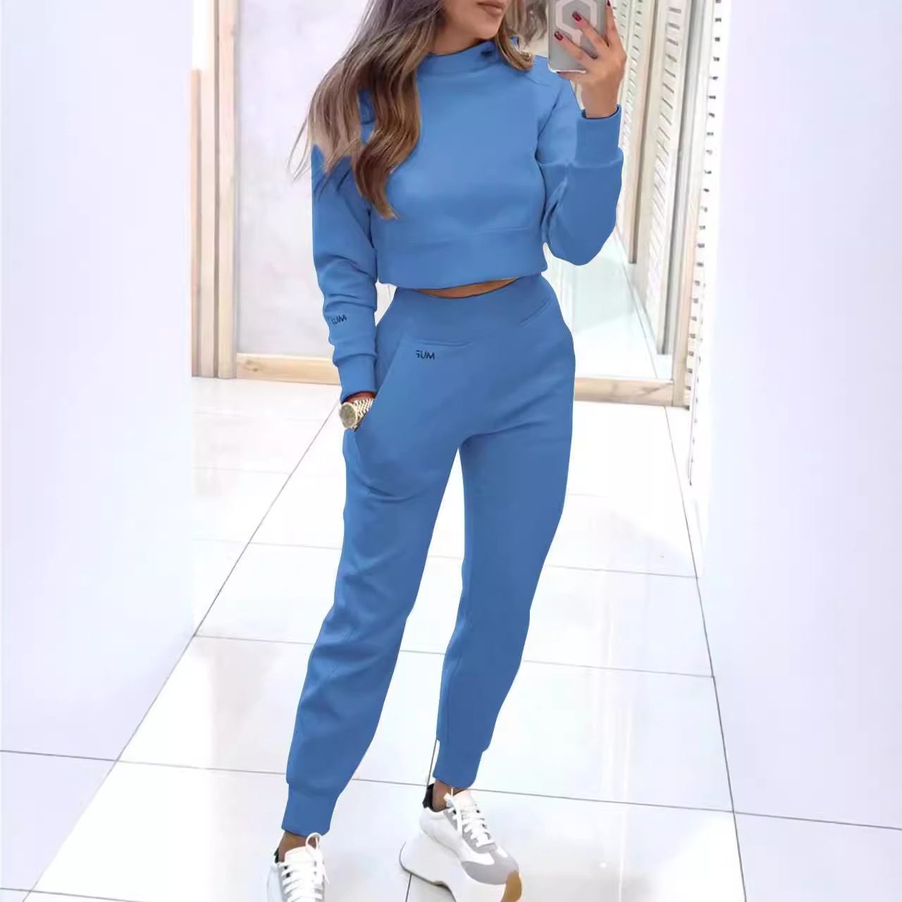 طقم رياضي نسائي أنيق بياقة مرتفعة، يتكون من بلوزة قصيرة بأكمام طويلة وتصميم "بلوفر"، مع بنطال ضيق مزود بجيوب، بلون سادة ليناسب إطلالتك اليومية المريحة. - الصورة 3